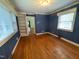 Comfortable bedroom with hardwood floors, built-in bookshelves, and soft natural light from the windows at 1609 Cypress Dr, Henderson, NC 27536