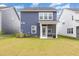 A spacious backyard features a blue home with a screened-in porch, and a lush green lawn at 1725 Winter Jasmine Ln, Wake Forest, NC 27587