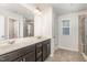 A bathroom features a double sink vanity, and a tiled shower at 1725 Winter Jasmine Ln, Wake Forest, NC 27587