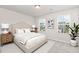 A serene bedroom features a bed with matching side tables, and two bright windows at 1725 Winter Jasmine Ln, Wake Forest, NC 27587