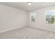 A bedroom features neutral carpet and walls, and two bright windows at 1725 Winter Jasmine Ln, Wake Forest, NC 27587