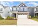 Charming two-story home featuring blue siding, stone accents, and a spacious two-car garage at 1725 Winter Jasmine Ln, Wake Forest, NC 27587
