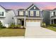 Charming two-story home featuring blue siding, stone accents, and a spacious two-car garage at 1725 Winter Jasmine Ln, Wake Forest, NC 27587