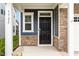 Welcoming front door with stone accents and stylish exterior lighting at 1725 Winter Jasmine Ln, Wake Forest, NC 27587