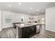 Bright open-concept kitchen with dark cabinets, granite counters, and stainless steel appliances at 1725 Winter Jasmine Ln, Wake Forest, NC 27587