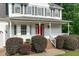 Inviting front porch of a two-story home with black shutters and a bright red door at 188 Worthington Ct, Clayton, NC 27527