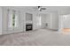 Open-concept living room with a fireplace, neutral carpet, and abundant natural light at 188 Worthington Ct, Clayton, NC 27527