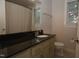 Bathroom featuring granite countertop, tile floor, vanity, and good natural light from the window at 1908 Smallwood Dr, Raleigh, NC 27605