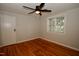 This bedroom features hardwood floors, neutral paint, and a modern ceiling fan with a closet at 1908 Smallwood Dr, Raleigh, NC 27605