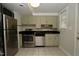 Functional kitchen featuring stainless steel appliances, light-colored cabinets, and a tile floor at 1908 Smallwood Dr, Raleigh, NC 27605