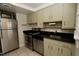 Well-lit kitchen with stainless steel appliances, light-colored cabinets, and updated fixtures at 1908 Smallwood Dr, Raleigh, NC 27605