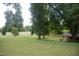 Open grassy lawn with a park shelter and trees surrounding the park at 1908 Smallwood Dr, Raleigh, NC 27605