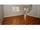 Open-concept living room boasting hardwood floors, light gray walls, and stairway at 1908 Smallwood Dr, Raleigh, NC 27605