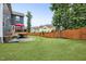 Spacious backyard features a manicured lawn, wooden fence, and a deck for outdoor enjoyment at 2100 Della Ct, Apex, NC 27502