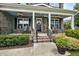 Inviting front porch featuring rocking chairs, decorative plants, and a charming wreath on the front door at 2100 Della Ct, Apex, NC 27502