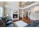 Spacious living room with a fireplace, hardwood floors, and a soaring two-story ceiling at 2100 Della Ct, Apex, NC 27502