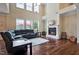 Bright living room with a fireplace, large windows, hardwood floors, and sectional seating at 2100 Della Ct, Apex, NC 27502