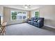Bright living room featuring plush carpeting, large windows, and a comfortable gray reclining sofa at 2100 Della Ct, Apex, NC 27502