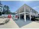 Community pool with chairs, tables, and red umbrellas, with a two story covered structure at 2100 Della Ct, Apex, NC 27502