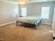 Bright main bedroom features plush carpet and natural light from windows at 224 Swann Trl, Clayton, NC 27527