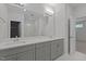Bright bathroom features a double vanity with modern fixtures, large mirror, and a tiled shower visible through an open door at 2329 Field Poppy Dr, Apex, NC 27502