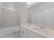 Bathroom with double vanity sinks, a shower with tub, and a large mirror at 2329 Field Poppy Dr, Apex, NC 27502