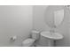 Compact powder room featuring a pedestal sink, toilet, and round mirror for a simple and functional space at 2329 Field Poppy Dr, Apex, NC 27502