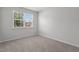 Bright bedroom features a large window providing ample natural light and neutral carpeting at 2329 Field Poppy Dr, Apex, NC 27502