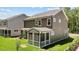 Exterior view showcasing the screened-in porch and lush backyard at 2329 Field Poppy Dr, Apex, NC 27502