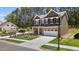 Side angle of the house showing the yard, two car garage, and green front lawn at 2329 Field Poppy Dr, Apex, NC 27502