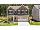 Charming two-story home featuring a brick facade, a two-car garage and manicured lawn at 2329 Field Poppy Dr, Apex, NC 27502