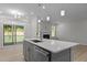 Kitchen island with sink, opening to the living room with a fireplace and sliding doors to the outside at 2329 Field Poppy Dr, Apex, NC 27502