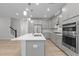 Modern kitchen features stainless appliances, island with sink, and view of stairs and other rooms at 2329 Field Poppy Dr, Apex, NC 27502