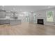Open concept living space with a fireplace, and a kitchen with modern lighting and stainless appliances at 2329 Field Poppy Dr, Apex, NC 27502