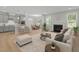 Open-concept living room seamlessly connecting the kitchen, dining area, and cozy fireplace at 2329 Field Poppy Dr, Apex, NC 27502