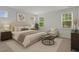 Staged bedroom with a large bed and lots of natural light at 2329 Field Poppy Dr, Apex, NC 27502