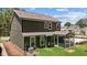 Exterior shot of the back of the house with a screened porch, lawn, and wooded area at 2329 Field Poppy Dr, Apex, NC 27502