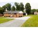 Charming brick home with gravel driveway, and well-maintained landscaping at 250 Patterson Dr, Roxboro, NC 27573