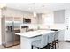 Open kitchen with stainless appliances, island with bar seating, and gray shaker cabinets at 250 Patterson Dr, Roxboro, NC 27573