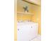 Bright laundry room with a new white washer and dryer, plus stylish shelf and yellow walls at 250 Patterson Dr, Roxboro, NC 27573