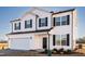 Attractive two-story home with white siding, dark shutters, well-manicured landscaping, and an attached two-car garage at 285 Johnson Ridge Way, Four Oaks, NC 27524