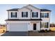 Charming two-story home featuring a white exterior, black shutters, and an attached two-car garage at 285 Johnson Ridge Way, Four Oaks, NC 27524