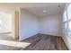 Bright, empty room showcasing modern wood-look floors, ample natural light, and neutral walls at 285 Johnson Ridge Way, Four Oaks, NC 27524