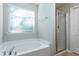 Bathroom with a soaking tub and glass-enclosed shower, providing a spa-like experience in a serene setting at 296 Johnson Ridge Way, Four Oaks, NC 27524