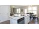 Open kitchen with island seating, stainless appliances, and adjacent dining area at 296 Johnson Ridge Way, Four Oaks, NC 27524