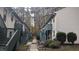 View of condos within a complex, with individual entrances and stairs. Bushy landscaping is shown between each building at 311 Ashley Forest Rd # Bldg E, Chapel Hill, NC 27514