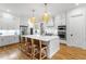 Gourmet kitchen features a center island with seating, custom cabinets, and high-end stainless steel appliances at 3160 Mantle Ridge Dr, Apex, NC 27502