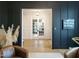 Cozy living room features dark paneled walls, modern light fixture and a glimpse into other rooms at 3160 Mantle Ridge Dr, Apex, NC 27502