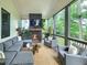 Relaxing screened patio boasts an inviting stone fireplace, ample seating, and views of a lush backyard at 3160 Mantle Ridge Dr, Apex, NC 27502