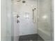 Modern shower with white marble tile, black pebble floor, and a built-in seat for a luxurious bathing experience at 3160 Mantle Ridge Dr, Apex, NC 27502